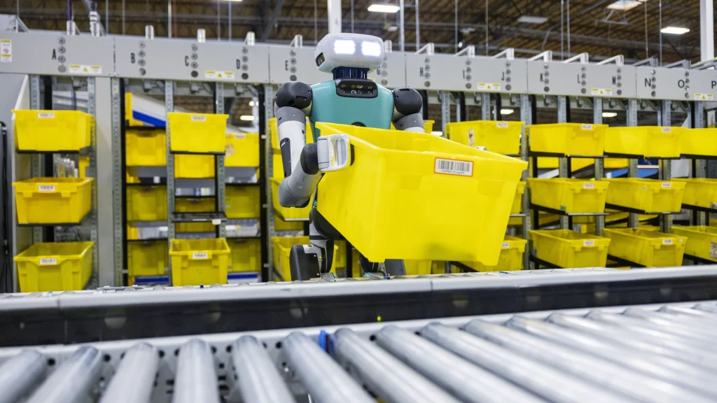 Робот Digit компании Agility Robotics переносит контейнер на складе Amazon