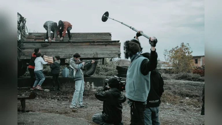 A director discusses a scene with a small film crew in a studio in Kazakhstan, with a camera and monitor nearby. A candid documentary-style shot with no text.