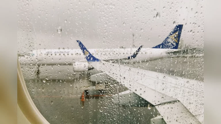 Перрон аэропорта Алматы: самолёт Air Astana и сотрудник наземной службы рядом. Документальный кадр при естественном свете, без текста.
