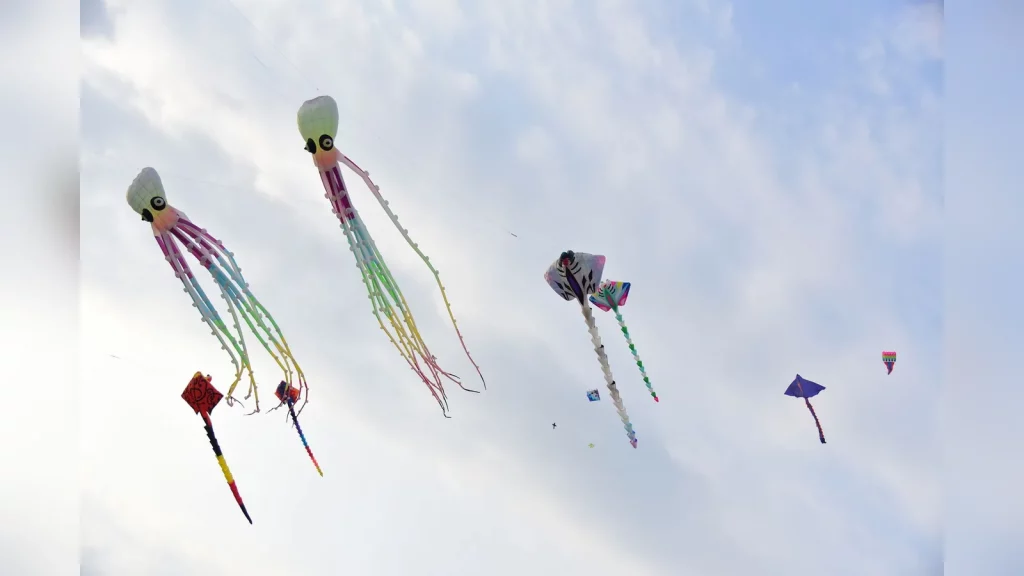 Families with children fly colourful kites under an open sky at Shymkent City Park in Shymkent, sharing moments of joy.