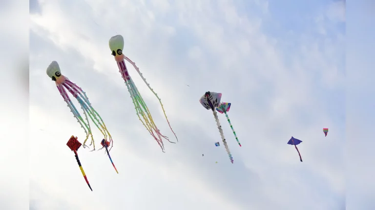 Families with children fly colourful kites under an open sky at Shymkent City Park in Shymkent, sharing moments of joy.