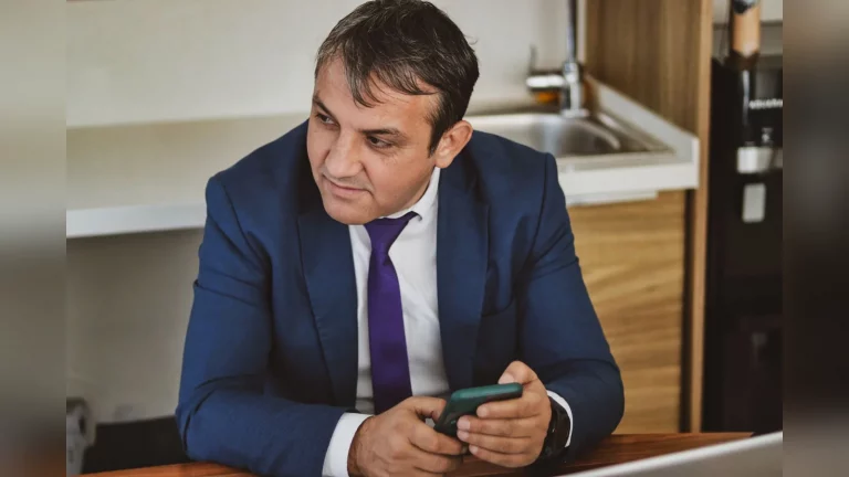 A Kazakhstani entrepreneur films a short video of a product on a smartphone in a small shop in Almaty. A candid moment at work in natural light, with no text.